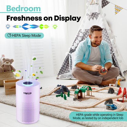 Man playing with a toy train set in a bedroom with a VNIUP air purifier.